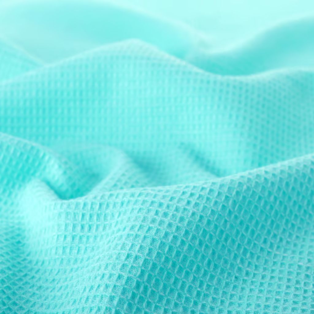 Fresh Vent Breathable Sports Cloth: Stay Cool While Active 9 "Close-up of light turquoise fabric with a waffle weave pattern, draped in soft folds."
Fresh Vent Breathable Sports Cloth: