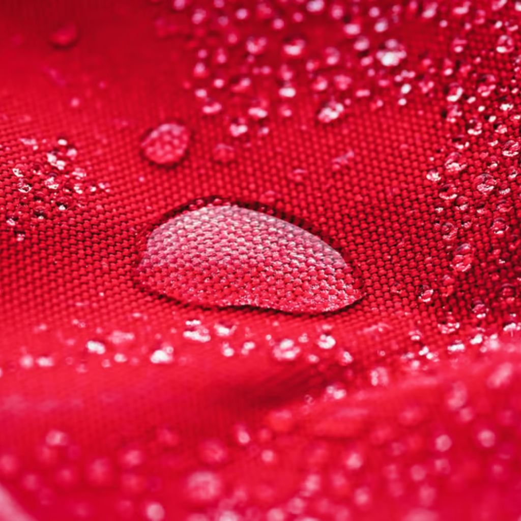 Alt text: "Macro shot of vibrant red fabric with water droplets scattered on the surface."
Does Storm-Proof Fabric: