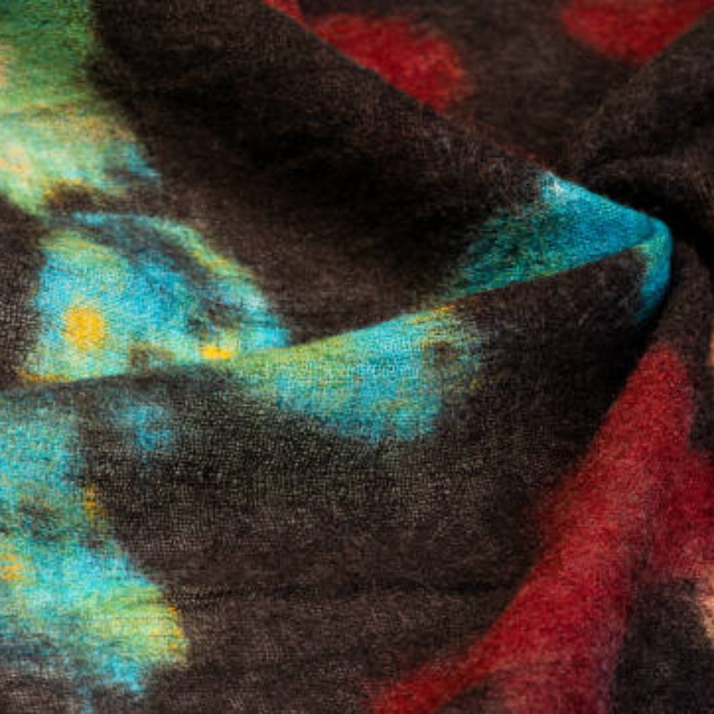 Alt text: Close-up of folded textured fabric with an abstract pattern in dark brown/gray as the base and bold splashes of blue, teal, yellow, and red.

Arctic Hug Comfort Weave: