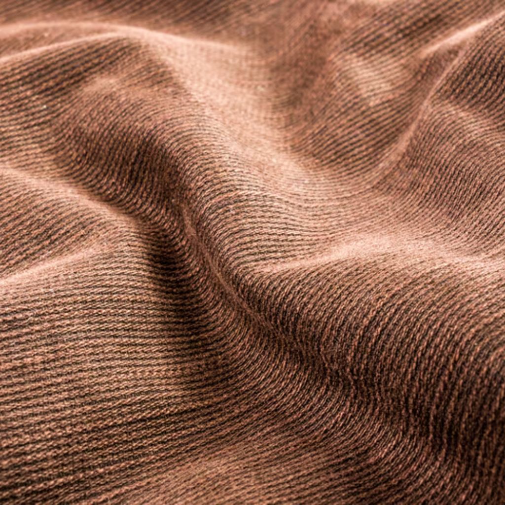 Warm Aura Fabric Explained:Why It’s Perfect for Cold Weather 9 Alt text: Close-up of rumpled brown fabric with a visible weave pattern and dark horizontal lines; folds create shadows and highlights, emphasizing the fabric’s texture.
Warm Aura Fabric Explained: