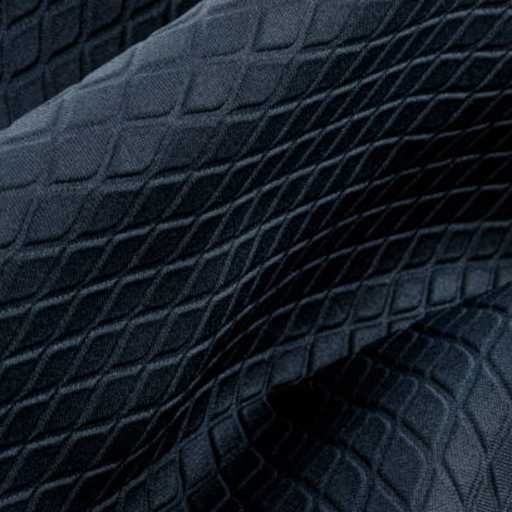Alt text: Close-up of dark blue fabric with a textured diamond pattern; folds create light and shadow, giving a three-dimensional look.What Is Thermo Guard Pro Fabric?
