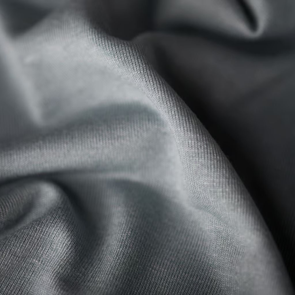 What Is Arctic Fusion Tech Fabric? Features, Benefits & Uses 10 Alt text: Close-up of gray fabric with visible folds and curves. The texture shows a knit/woven pattern, with lighting highlighting contours and shadows to emphasize depth.
What Is Arctic Fusion Tech Fabric?