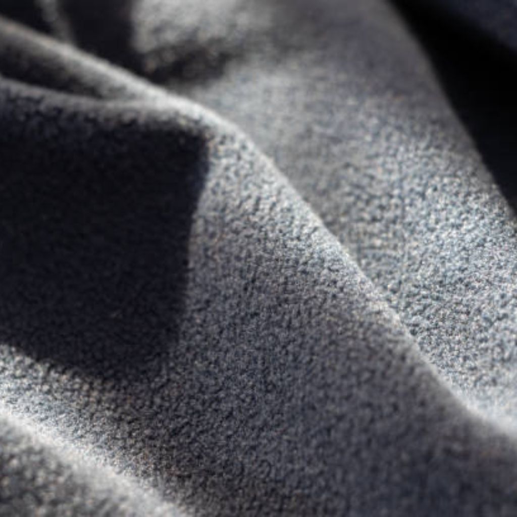 Crystal Fleece Pro Fabric: Premium Warmth and Comfort Guide 9 "Close-up of wrinkled gray fleece fabric with a soft, fuzzy pile. The fabric is folded, creating shadows and highlights that reveal its textured surface."
Crystal Fleece Pro Fabric: