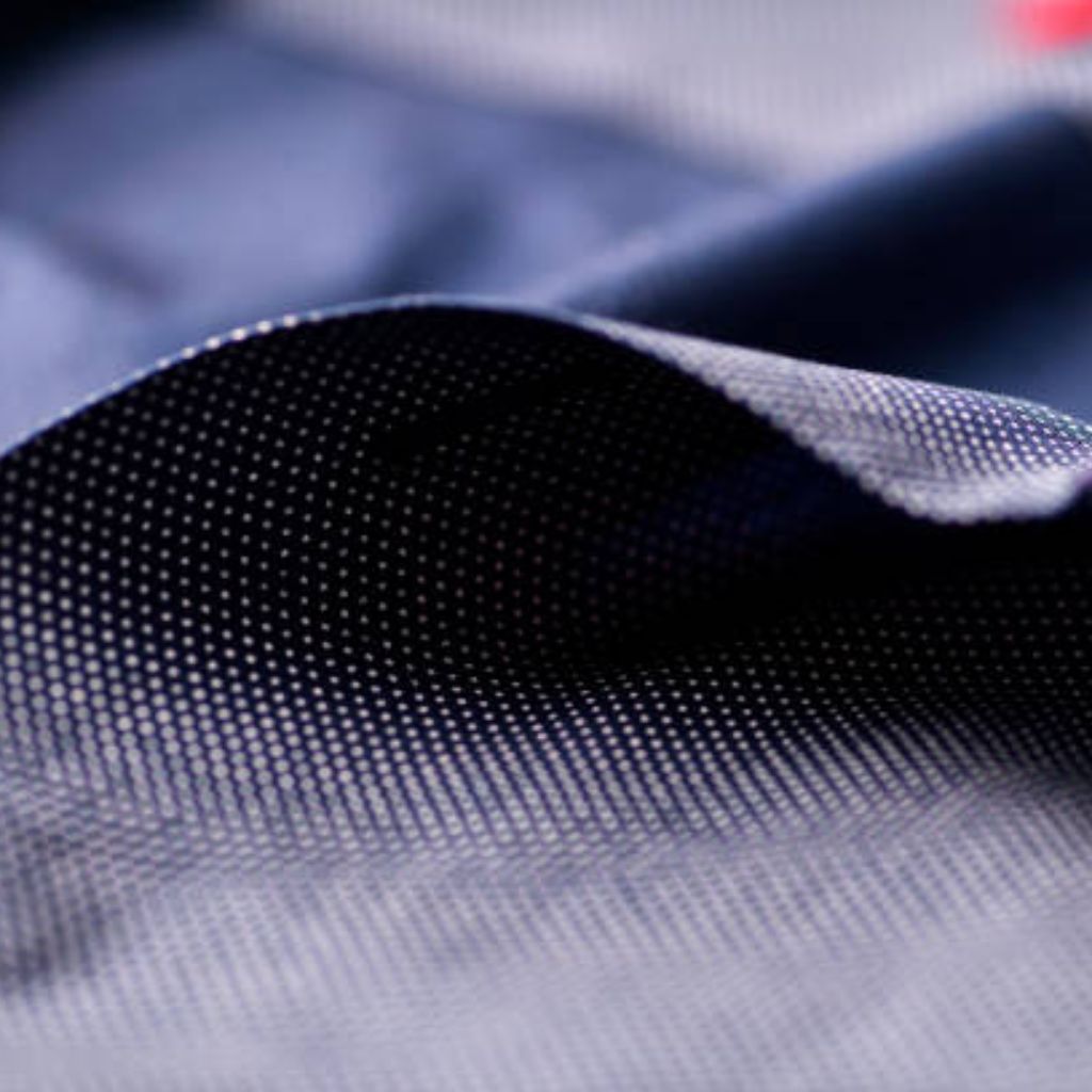 Thermo Shield Performance Fabric: Technology for Activewear 10 Close-up of navy blue fabric with small white dot pattern and subtle sheen, showing folds and shading.
Thermo Shield Performance Fabric:
