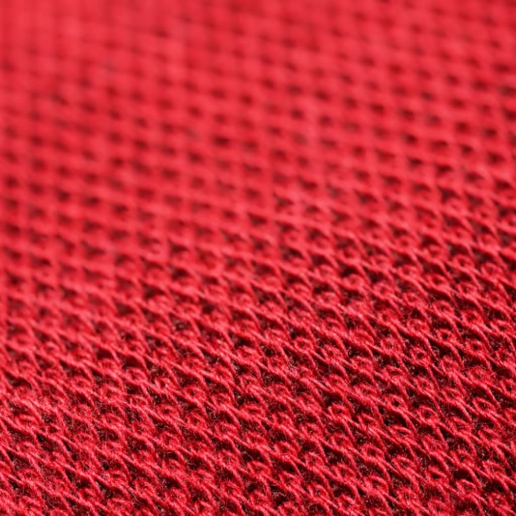 What Is Thermal Core Fabric for Winter Wear? Complete Guide 7 Alt text: A close-up macro of red woven fabric with a repeating diamond pattern and shallow depth of field.
What Is Thermal Core Fabric for Winter Wear?