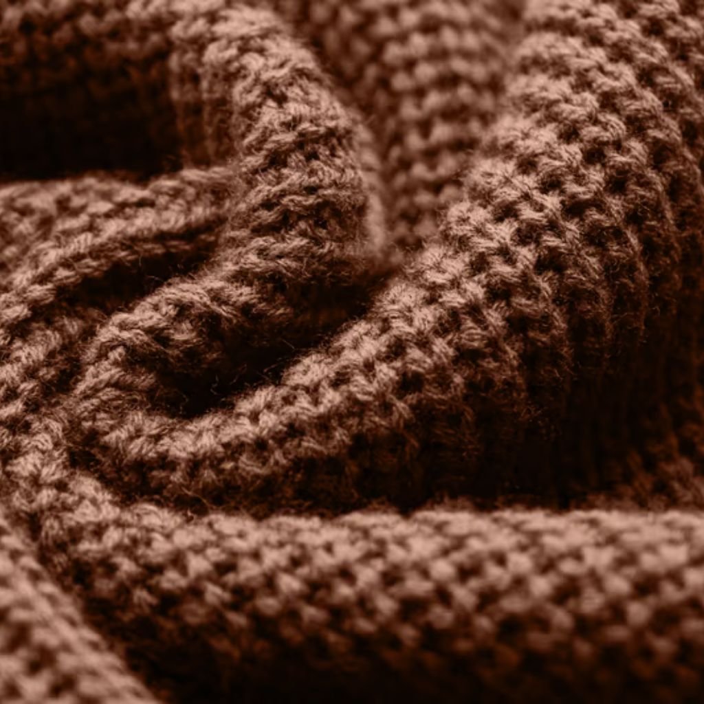 What Is Thermal Core Fabric for Winter Wear? Complete Guide 12 Alt text: A close-up view of brown knitted fabric, showing a rich texture with tightly interwoven yarns and prominent ridges that create a three-dimensional surface.
What Is Thermal Core Fabric for Winter Wear?