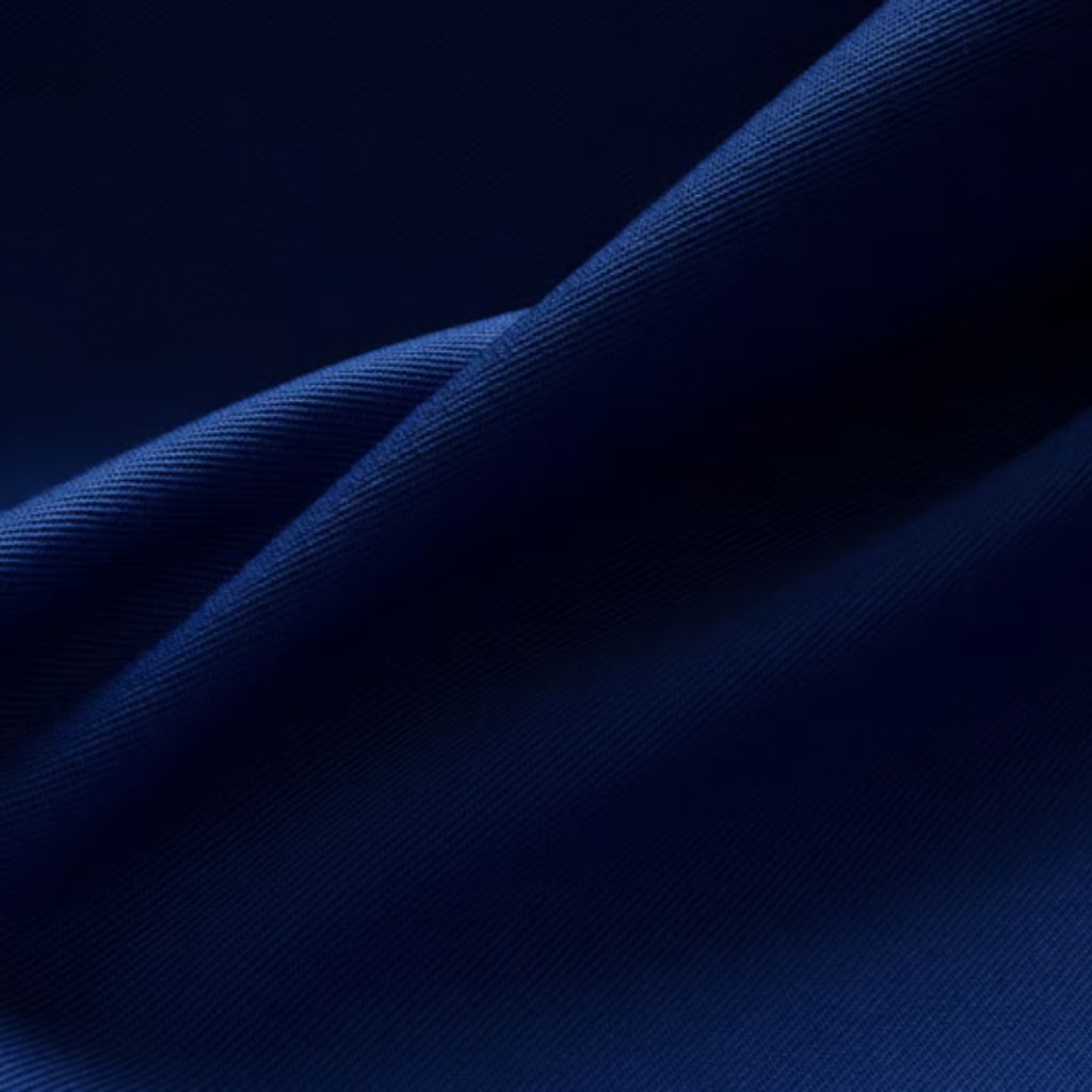 What Is Arctic Fusion Tech Fabric? Features, Benefits & Uses 11 Alt text: Close-up shot of dark blue fabric with a subtle diagonal weave. The material is draped in gentle folds, with dramatic lighting creating a gradient from lighter blue to nearly black, giving a three-dimensional look.
What Is Arctic Fusion Tech Fabric?