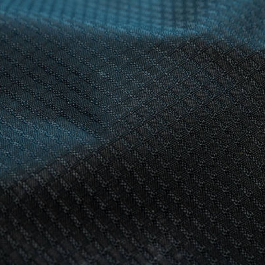 Close-up of textured fabric in dark blue and black with a grid-like and diagonal weave pattern.Hyper Cool Performance Weave Explained:
