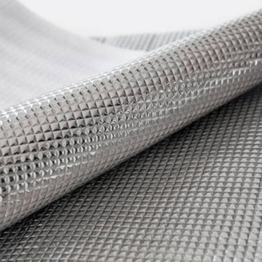 Thermo Shield Performance Fabric: Technology for Activewear 11 A roll of silver foil material with a diamond pattern, partially unrolled to show a white textured backing.Thermo Shield Performance Fabric: