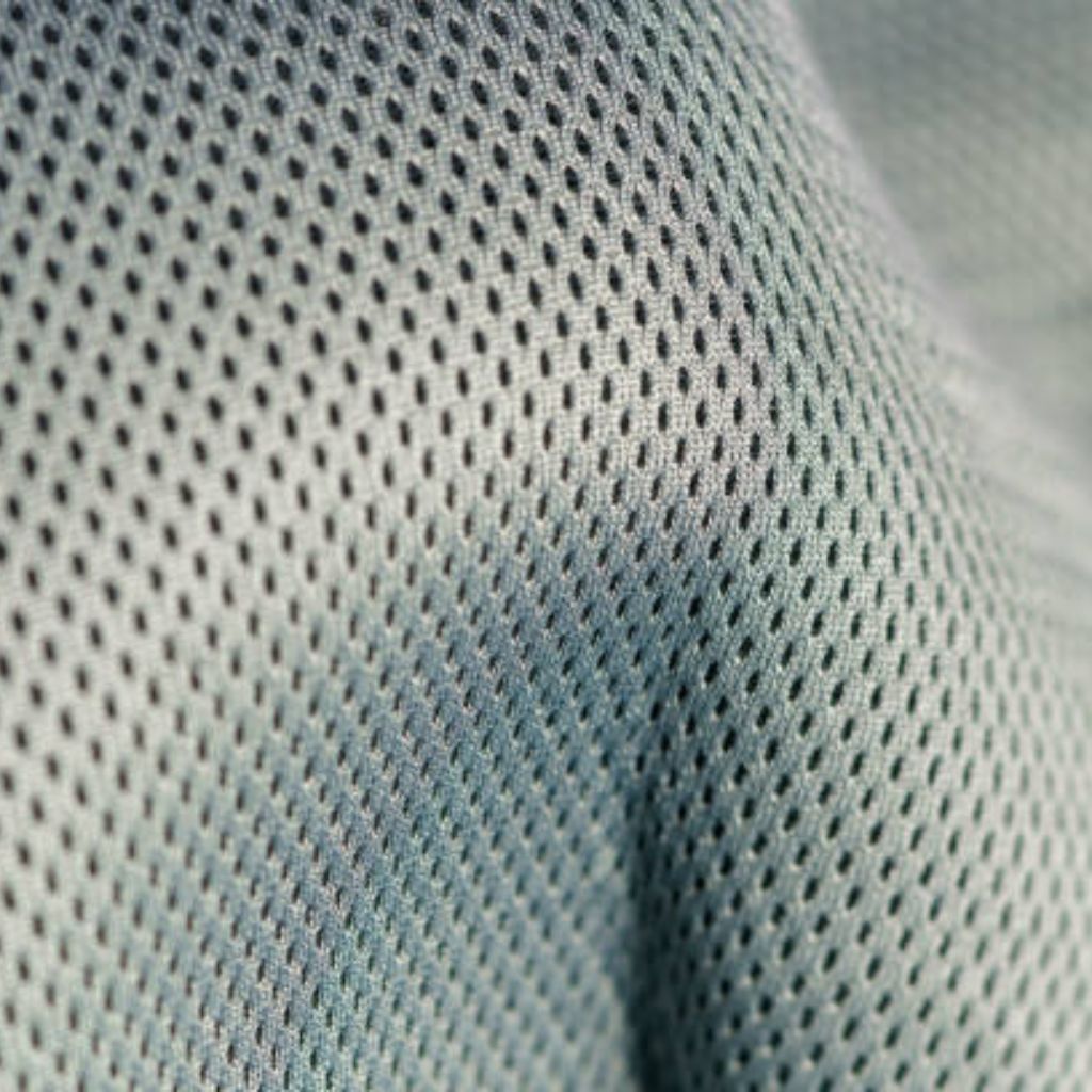 Fresh Vent Breathable Sports Cloth: Stay Cool While Active 11 "Close-up of light-blue fabric with a grid of small perforations, showing draped folds that create shadows and highlights."
Fresh Vent Breathable Sports Cloth:
