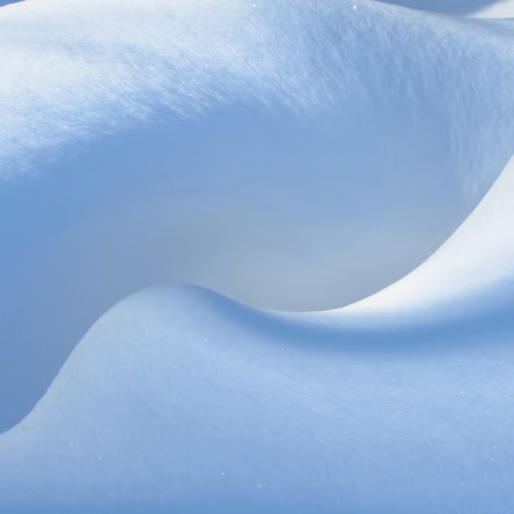 Alt text: Close-up of a wind-sculpted snowdrift with smooth curves, predominantly white and light blue tones.
Why Alpine Therm Winter Fabric?