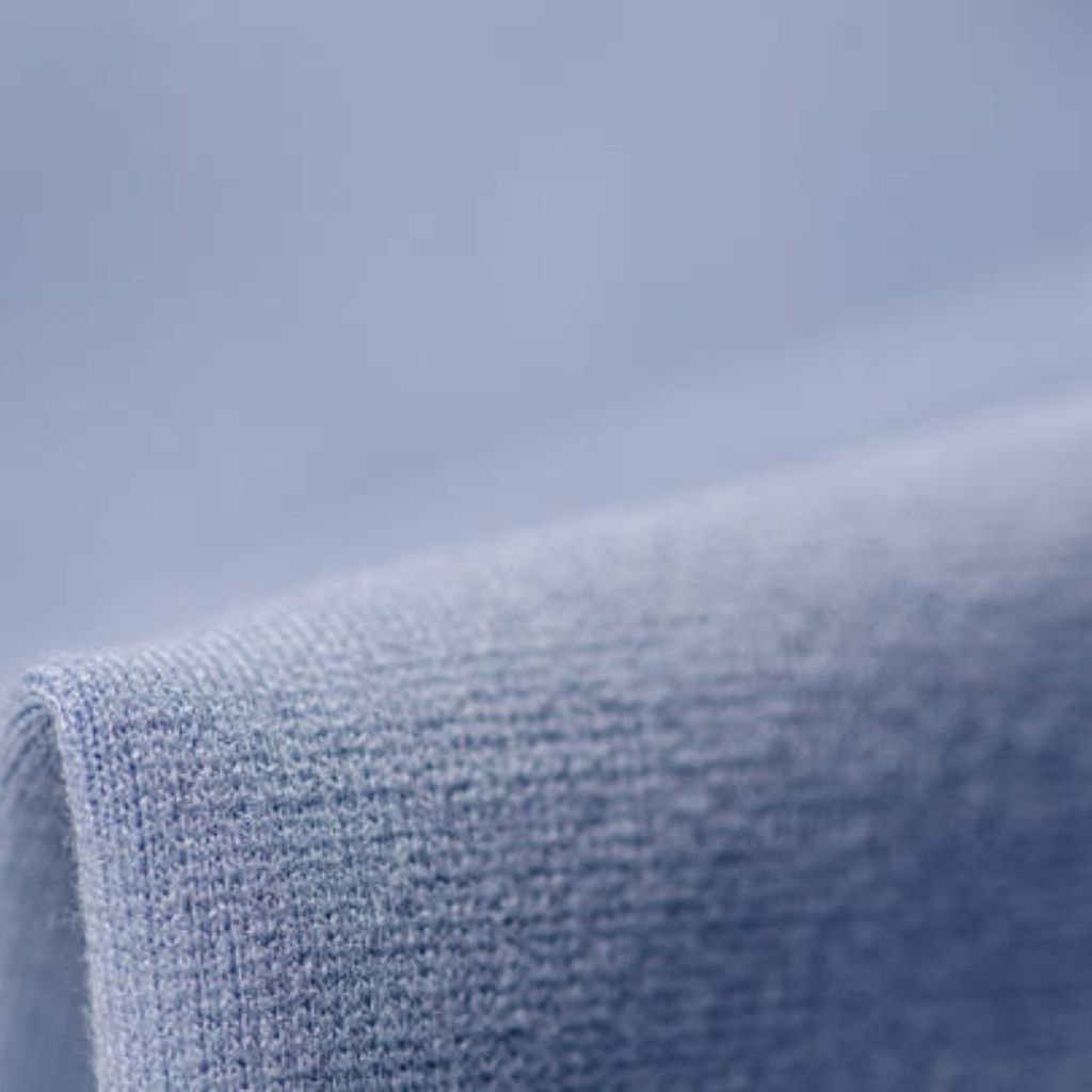 Frost Flex Stretch Thermal Fabric: Warmth Meets Flexibility 6 Alt text: Close-up of light blue knitted fabric, showing the weave texture with diffused lighting and soft shadows.
Frost Flex Stretch Thermal Fabric:
