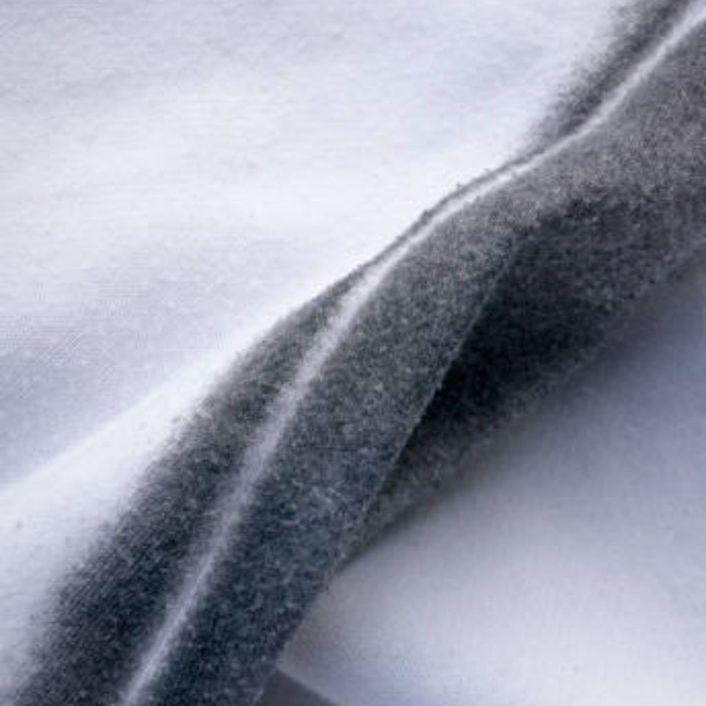 Alt text: Close-up of soft, fuzzy fabric in white and gray tones, with a gray fold running diagonally across the image.Frost Core Insulated Fabric:
