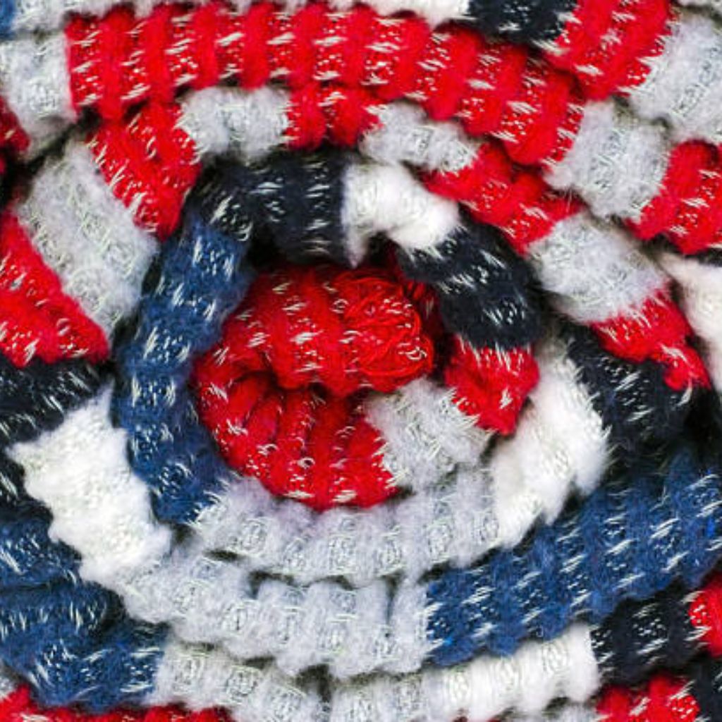 Alt text: Close-up of a tightly rolled textured blanket in red, white, and blue, forming a spiral pattern with alternating color rings and a red core.

Arctic Hug Comfort Weave: