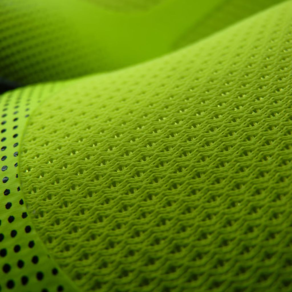 Close-up of bright green athletic mesh fabric with a repeating pattern and a dotted side band.
Aero Flex Pro Fabric:
