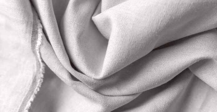 Recycled Cashmere Twill Fabric Close-up of light gray woven fabric with soft folds and visible texture.