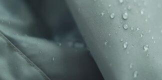 Does Storm-Proof Fabric: Truly Protect You From Harsh Storms Alt text: "Close-up of light gray shell fabric with water droplets on the surface." Does Storm-Proof Fabric: