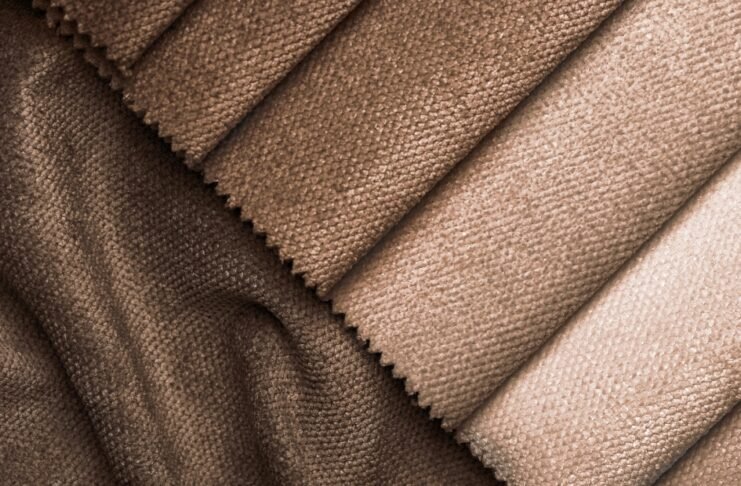 Types of Grade C Cashmere Wool Fabric Guide Close-up of diagonal swatches in brown tones with soft, textured fabric surfaces (likely velvet or corduroy), showcasing color variation.