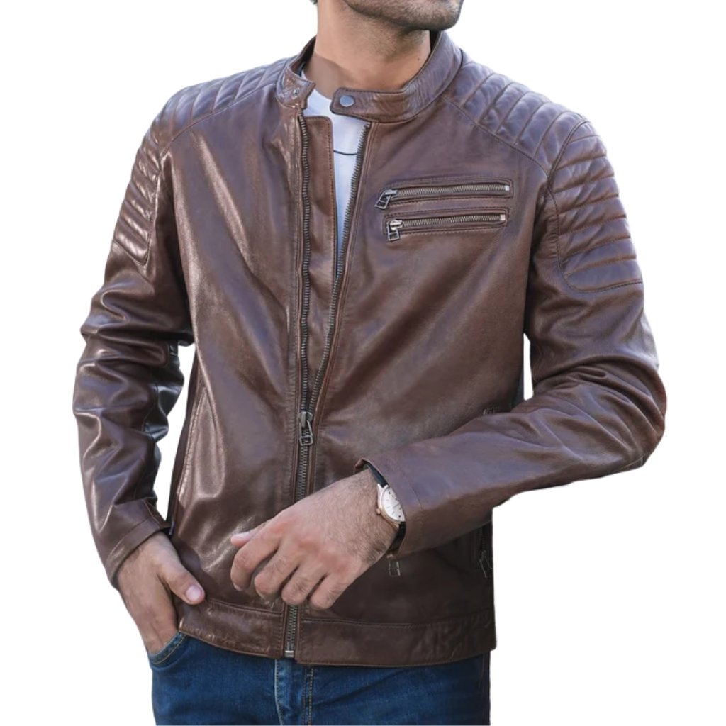 A man wearing a brown leather jacket with a front zipper and two zippered chest pockets, paired with blue jeans. He has a watch on his left wrist and one hand in his pocket, against a white background.