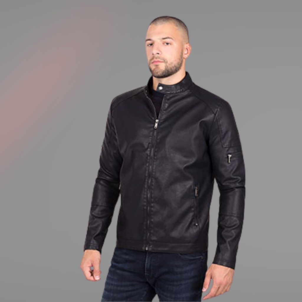 Eco Leather Jacket Crafted for Sustainable Modern Style Wear 4 A man with a short haircut and beard is standing facing forward, wearing a black leather jacket and dark jeans. The background is a gradient of light gray to faded red.