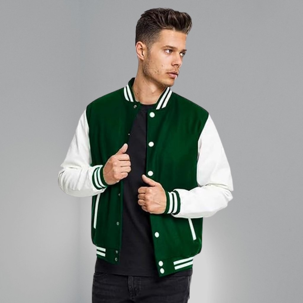 A young man stands in a studio wearing a green and white varsity jacket over a black T-shirt and black jeans. He is shown from the waist up, with his hands near the jacket closure.College Style Jacket