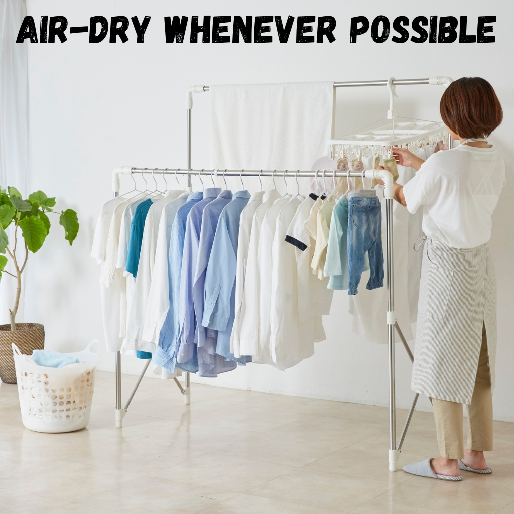 Sherpa-Lined Half-Zip Hoodie: Cozy Winter Essential 4 A woman hangs shirts and a pair of jeans on a metal indoor drying rack, with a plant in a woven basket and a laundry basket nearby. The shirts are white and blue, and the scene emphasizes air-drying clothes indoors.