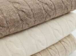 Close-up of blended cashmere wool fabric, showing the knit texture and folded layers in neutral beige and taupe tones.Types of Blended Cashmere Wool Fabric