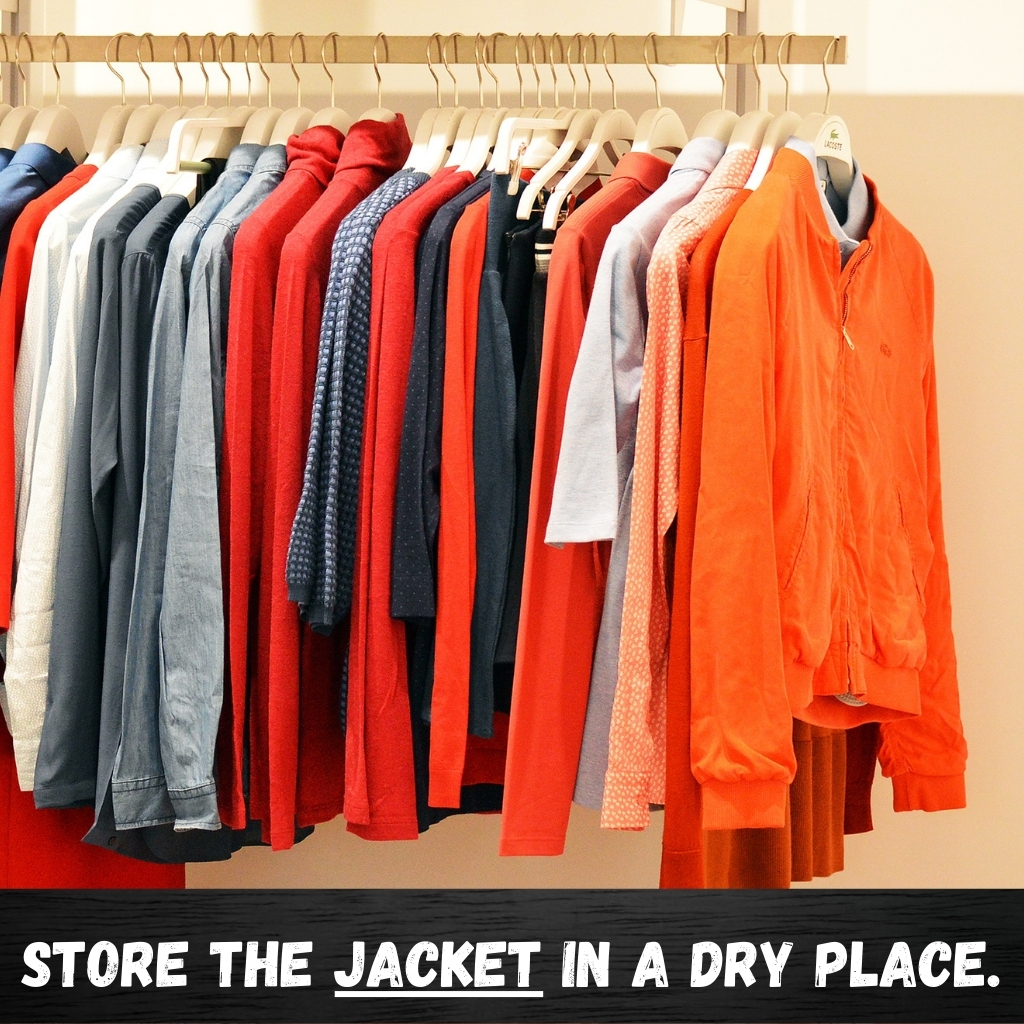 The image shows a row of jackets on a clothing rack, featuring a spectrum from light to dark reds and oranges, plus some gray and blue tones. The jackets hang on white hangers against a pale background, and a bold caption at the bottom instructs to store the jacket in a dry place.