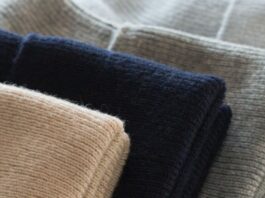 Cashmere-Cotton Blend Close-up of folded cashmere-cotton blend sweaters in beige, black, and gray.
