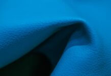 Swift Dry Athletic Performance Cloth: Maximum Breathability "Close-up of bright blue fabric with folds and shadows, showing a grainy texture and areas of light and dark."Swift Dry Athletic Performance Cloth: