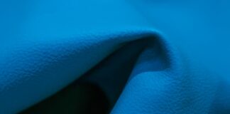 Swift Dry Athletic Performance Cloth: Maximum Breathability "Close-up of bright blue fabric with folds and shadows, showing a grainy texture and areas of light and dark."Swift Dry Athletic Performance Cloth: