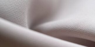 Flex Motion Stretch Fabric: The Future of Activewear Comfort Close-up of folded light grey fabric with a subtle texture and soft lighting. Flex Motion Stretch Fabric: