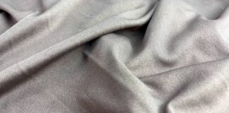 Hyper Stretch Athletic Fabric: Stretch, Comfort & Durability Close-up of soft gray fabric with a subtle sheen, showing folds and a visible weave texture.Hyper Stretch Athletic Fabric: