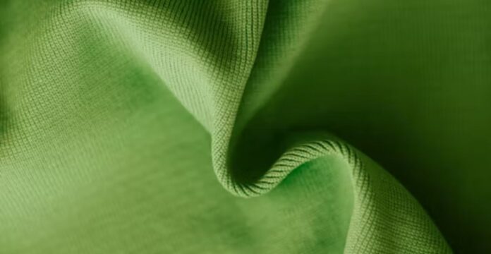 Close-up of a soft, bright green fabric with gentle folds and textures, suggesting a lightweight, smooth material. Sweat Flow Pro Fabric:
