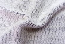 Dry Flow Cooling Knit: Best Fabric for Hot Weather Training Close-up photo of light gray knit fabric with a textured, slightly wrinkled surface and visible interwoven stitches. Dry Flow Cooling Knit: