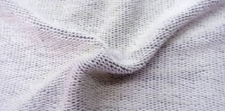 Dry Flow Cooling Knit: Best Fabric for Hot Weather Training Close-up photo of light gray knit fabric with a textured, slightly wrinkled surface and visible interwoven stitches. Dry Flow Cooling Knit: