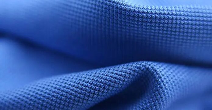 “Close-up of blue fabric with a textured, grid-like weave, likely from a winter coat.” Rapid Dry Sports Fabric: