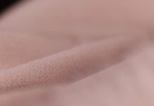 Arctic Cool Performance Fabric: Ultimate Cooling Sportswear A close-up of soft, light-pink fleece or fabric with a plush texture, suggesting a warm winter coat material.Arctic Cool Performance Fabric: