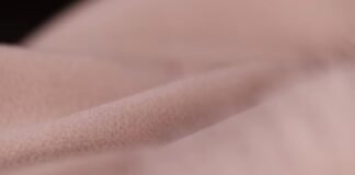 Arctic Cool Performance Fabric: Ultimate Cooling Sportswear A close-up of soft, light-pink fleece or fabric with a plush texture, suggesting a warm winter coat material.Arctic Cool Performance Fabric:
