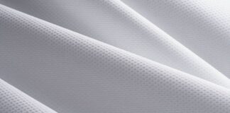 Ice Vent Performance Fabric: Stay Cool, Dry & Game-Ready Pro "Close-up of white winter coat fabric showing a fine, repeating square pattern with soft folds and gentle shadows highlighting its textured surface." Ice Vent Performance Fabric: