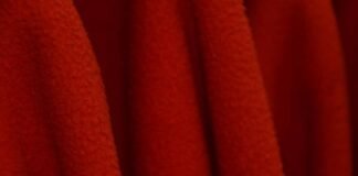 Arctic Pulse Activewear Fabric: Beat Heat, Boost Performance Close-up of soft, vibrant red fleece fabric with rich texture, deep folds, and subtle tonal variation — evoking warmth and comfort. Arctic Pulse Activewear Fabric: