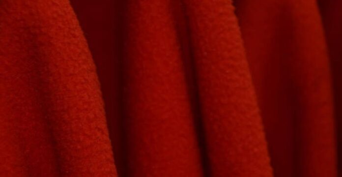 Arctic Pulse Activewear Fabric: Close-up of soft, vibrant red fleece fabric with rich texture, deep folds, and subtle tonal variation — evoking warmth and comfort. Arctic Pulse Activewear Fabric: