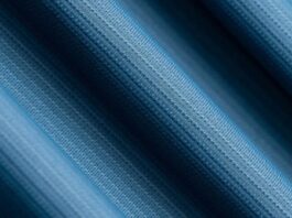 Glacier Dry Performance Fabric: Stay Cool, Dry & Game-Ready Close-up view of blue textured performance fabric with fine knit pattern, showing smooth folds and moisture-wicking material detail.Glacier Dry Performance Fabric: