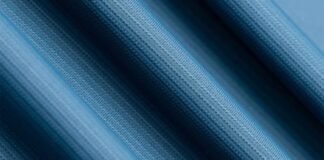 Glacier Dry Performance Fabric: Stay Cool, Dry & Game-Ready Close-up view of blue textured performance fabric with fine knit pattern, showing smooth folds and moisture-wicking material detail.Glacier Dry Performance Fabric:
