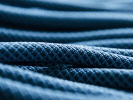 "Close-up of dark blue fabric with a textured, quilted pattern, suggesting a warm winter coat." Ultra Motion Dynamic Stretch Weave: