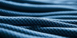 Ultra Motion Dynamic Stretch Weave: Advanced Sports Fabric "Close-up of dark blue fabric with a textured, quilted pattern, suggesting a warm winter coat." Ultra Motion Dynamic Stretch Weave: