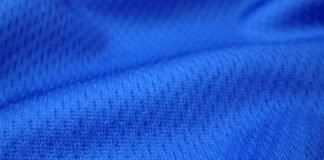 Dry Pulse Athletic Knit: Revolutionizing Sportswear Comfort "Close-up of rich navy blue textured knit fabric with visible interlocking loops and subtle dimensional folds, showing soft shadows and highlights that emphasize its thermal insulation properties." Dry Pulse Athletic Knit: