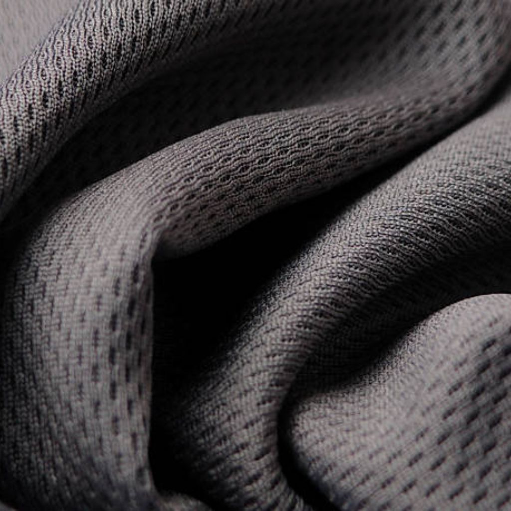 Close-up of textured gray fabric with a tight weave and small perforations, folded into soft creases and curves.
Hyper Stretch Athletic Fabric: