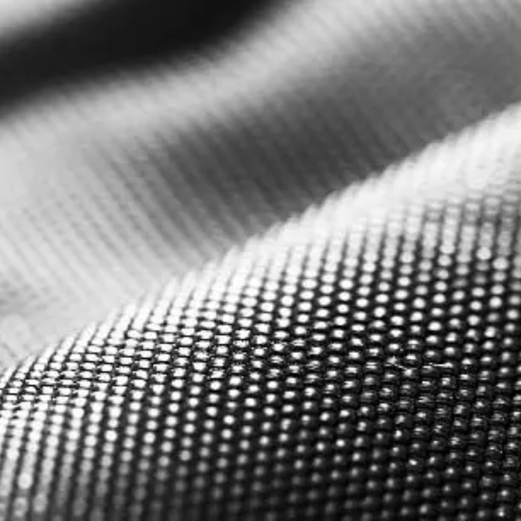 Quantum Flex Performance Fabric: Move Better, Perform Better 9 Macro close-up of black and white textured mesh fabric with a dotted grid pattern.Quantum Flex Performance Fabric:
