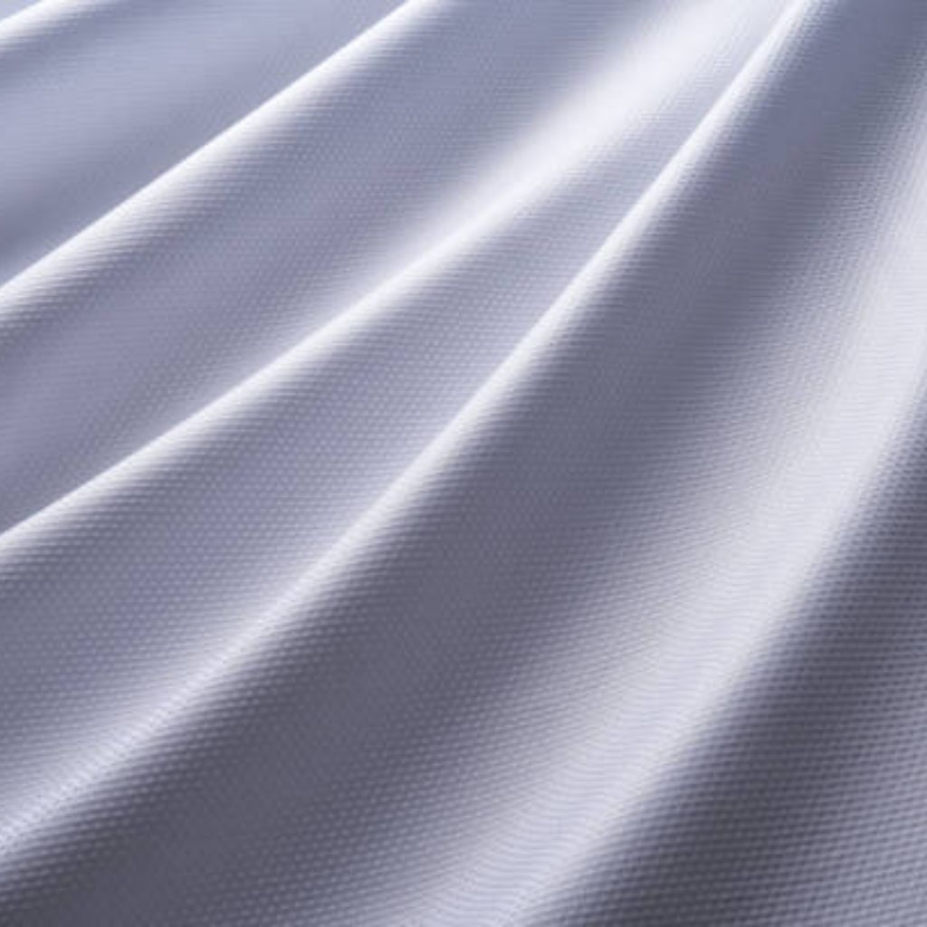 Glacier Cool Performance Fabric: Feel Cool, Stay Comfortable 9 "Close-up of white technical winter fabric showing a uniform grid of matte, raised micro-nodes (~80 µm tall) on a woven base; surface displays strong tonal contrast between highlights and shadows across natural draped folds."Glacier Cool Performance Fabric: